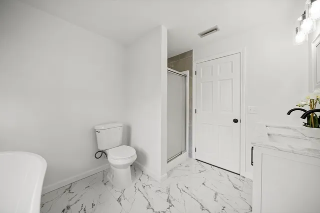 a bathroom with a granite countertop toilet and a sink