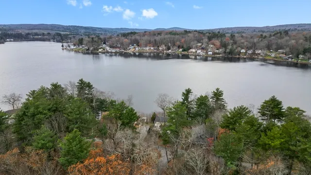 an aerial view of residential houses with outdoor space and lake view
