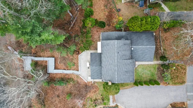 an aerial view of a house with a yard and large trees