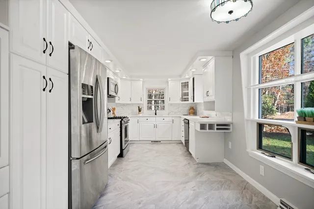 a kitchen with white cabinets and white appliances