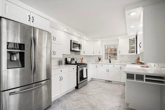 a kitchen with stainless steel appliances a refrigerator sink and microwave