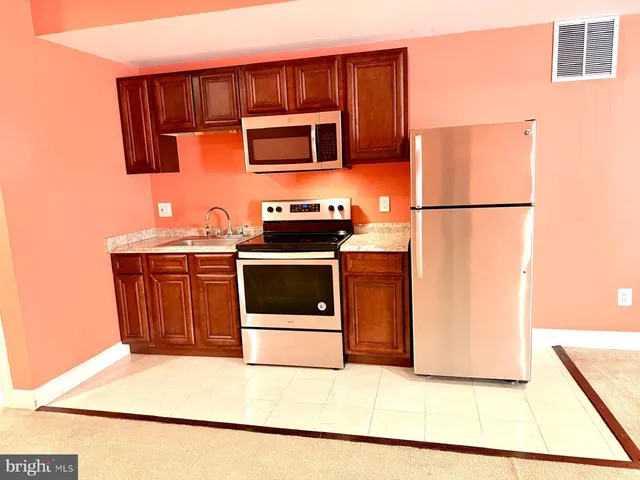 a kitchen with stainless steel appliances granite countertop a stove a refrigerator and a microwave