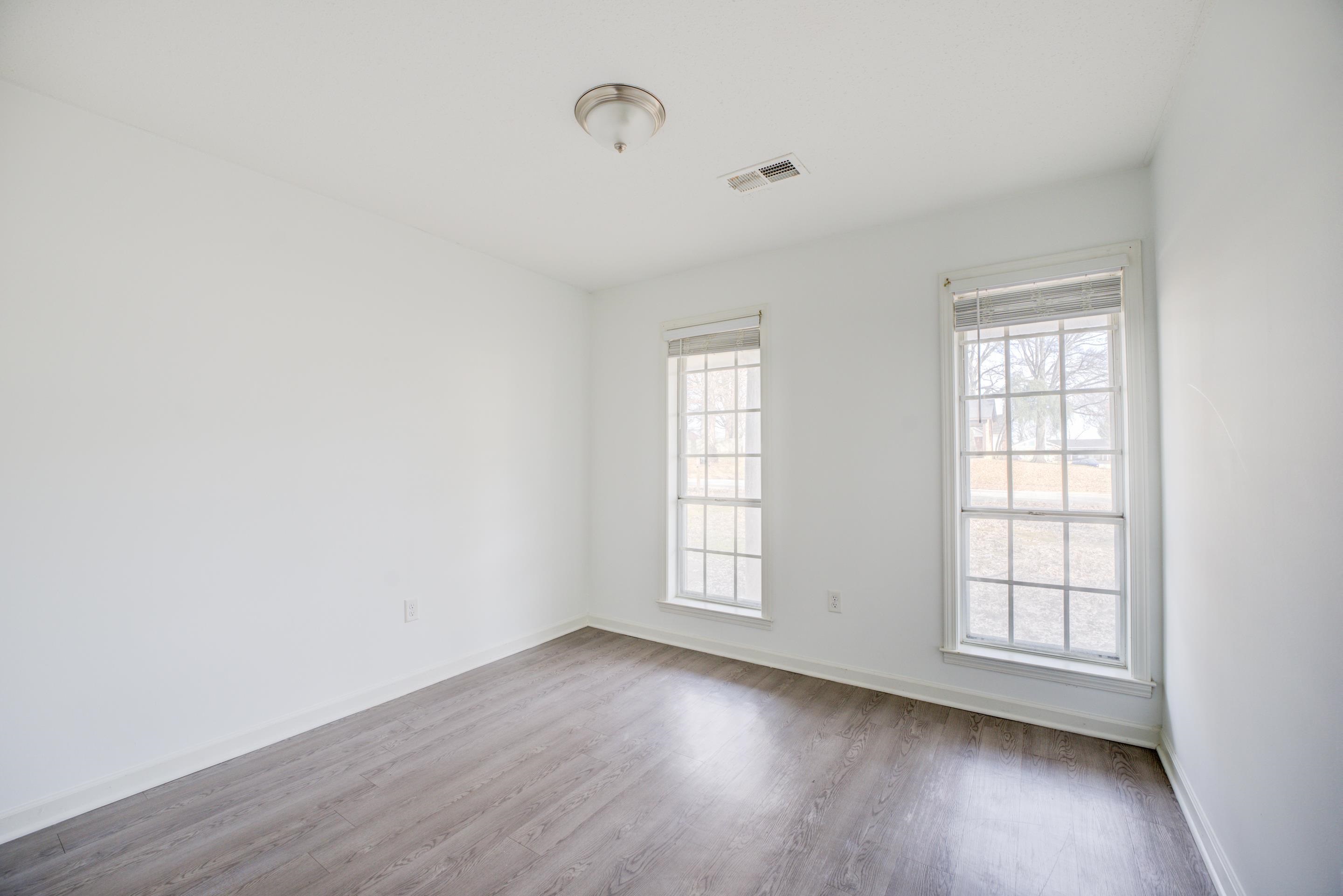 6725 Rockingham Road Memphis, TN 38141 - Photo 3 of 20 an empty room with wooden floor and windows
