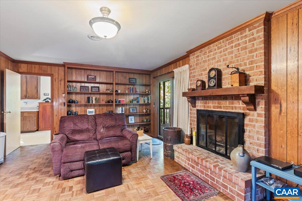 103 Vicar Court Charlottesville, VA 22901 - Photo 30 of 74 a living room with furniture a fireplace and a book shelf