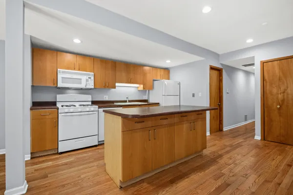 a kitchen with granite countertop white cabinets and white appliances