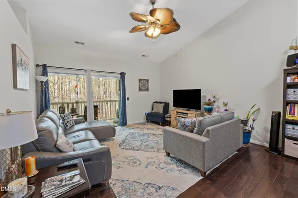 a living room with furniture a flat screen tv and a large window