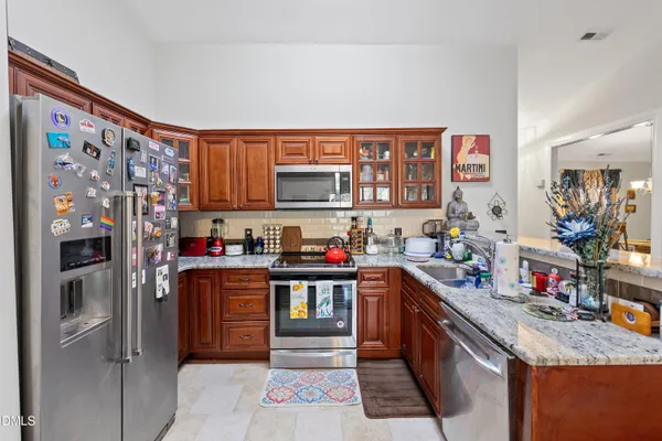 a kitchen with stainless steel appliances granite countertop a refrigerator and a stove