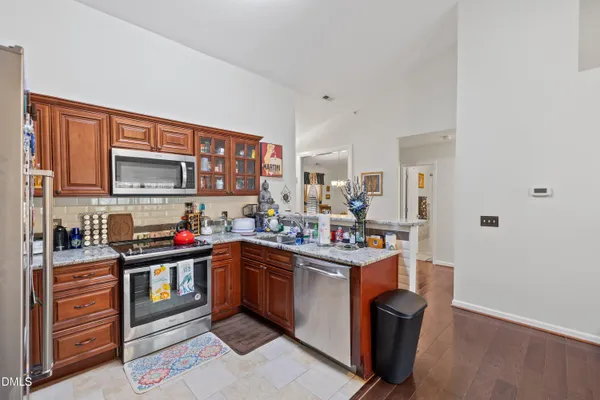 a kitchen with stainless steel appliances granite countertop a sink stove and cabinets