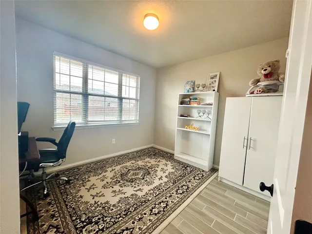 a view of a workspace with furniture and a window