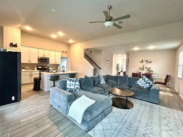 a living room with furniture kitchen view and a refrigerator