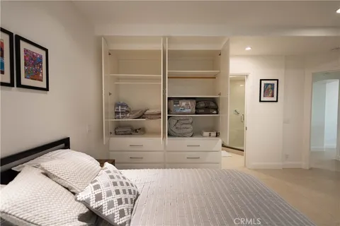 a spacious bedroom with a bed and wooden floor