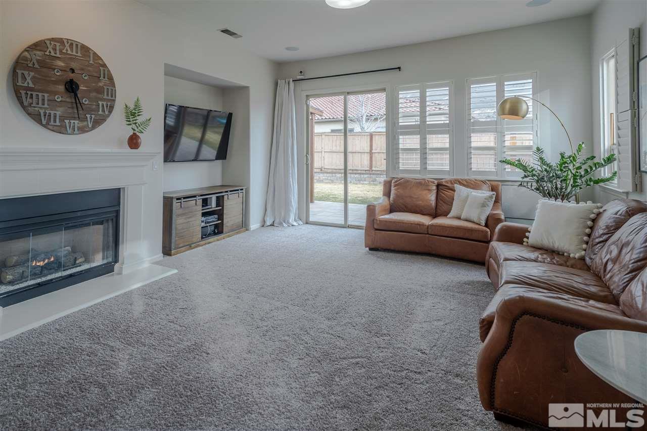 10590 Apple Mill Court Reno, NV 89521 - Photo 8 of 19 a living room with furniture a fireplace and a large window
