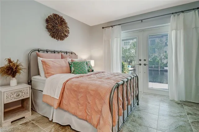 a bedroom with a bed and a flat tv screen on dresser