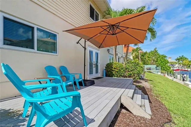a view of wooden table and chairs under an umbrella