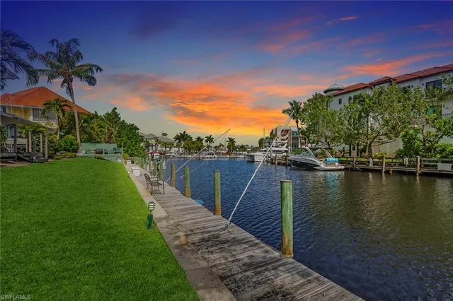 a view of a lake with a big yard and potted plants
