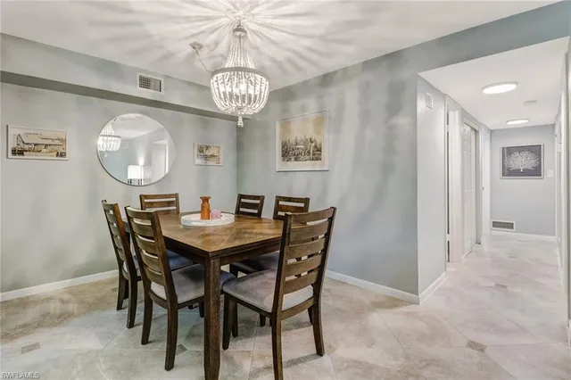 a view of a dining room with furniture a chandelier and wooden floor