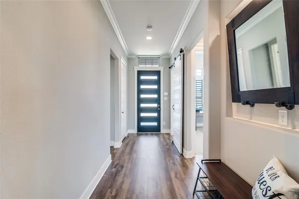 a view of a hallway with wooden floor and closet