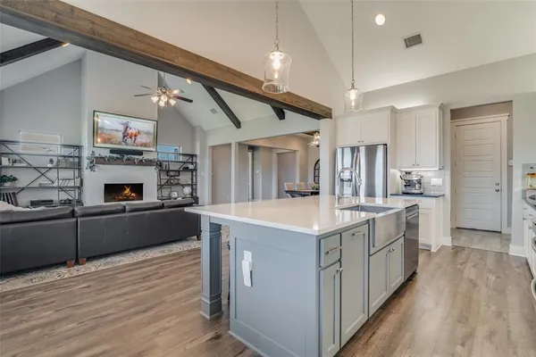 a large kitchen with stainless steel appliances granite countertop a lot of counter space and wooden floors