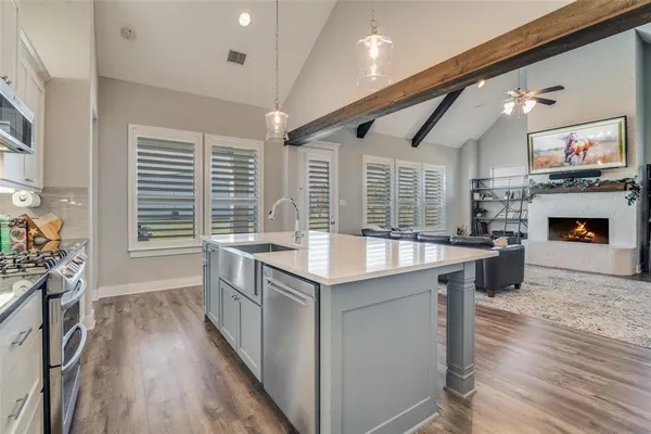 a kitchen with stainless steel appliances granite countertop a stove and a wooden floors