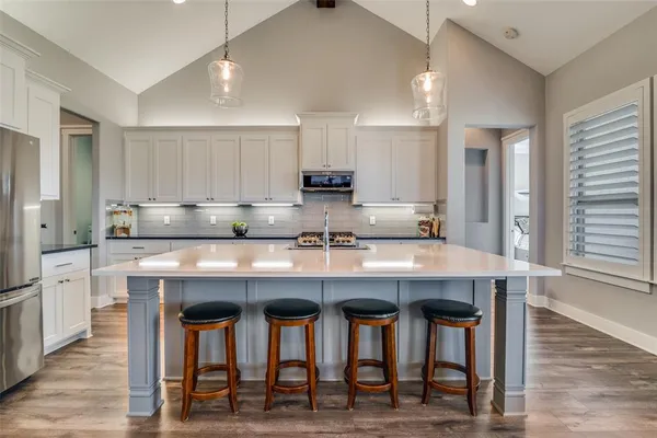 a kitchen with granite countertop white cabinets and stainless steel appliances
