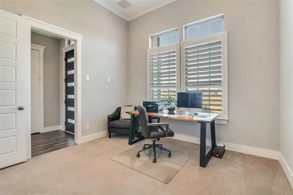 a view of a workspace with furniture and a window