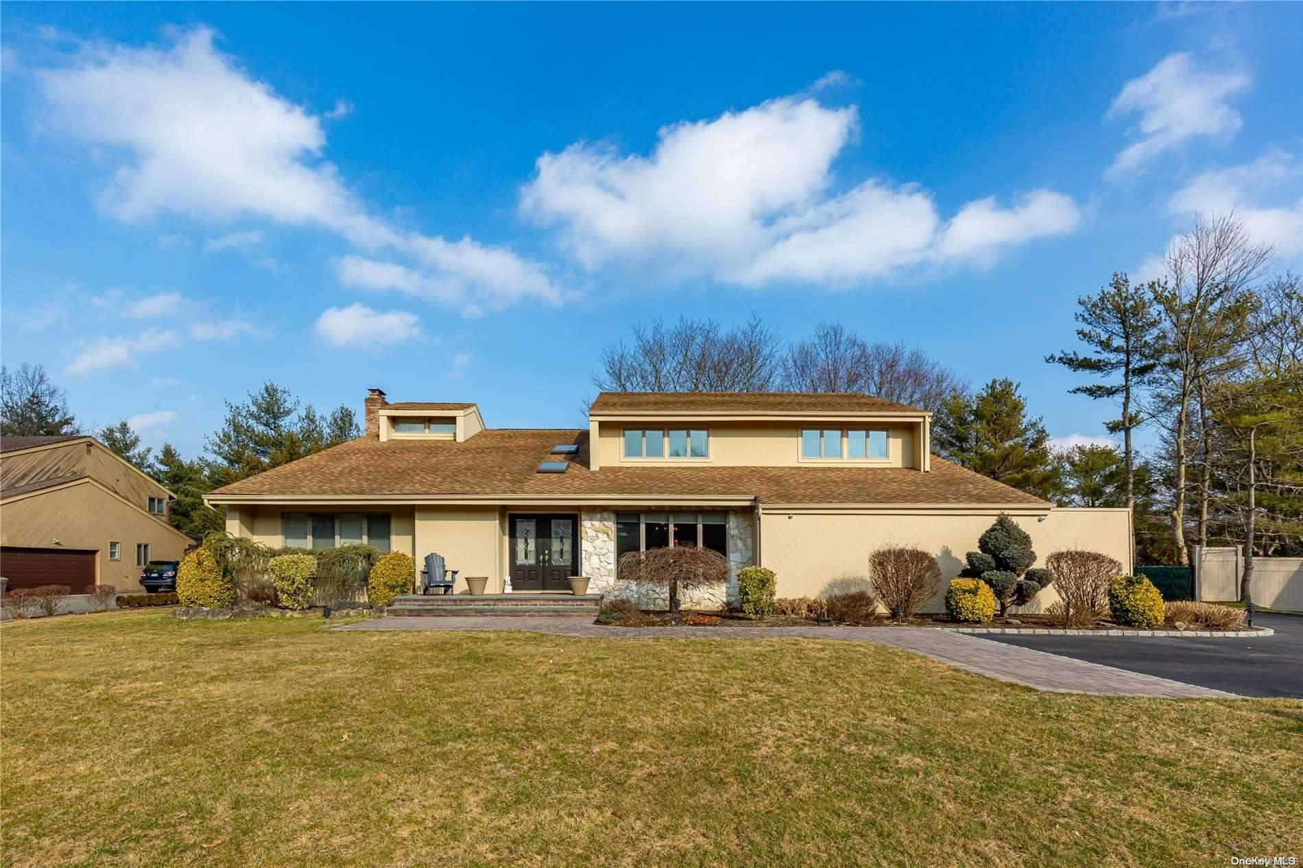 a view of a big house with a big yard and large trees