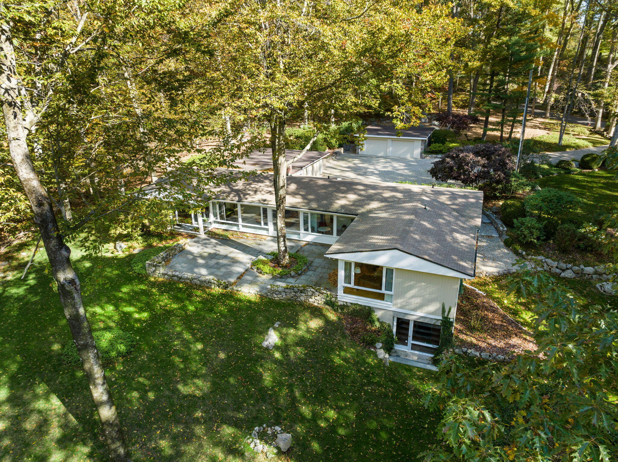 154 Indian Rock Road New Canaan, CT 06840 - Photo 27 of 33 a backyard of a house with table and chairs under an umbrella