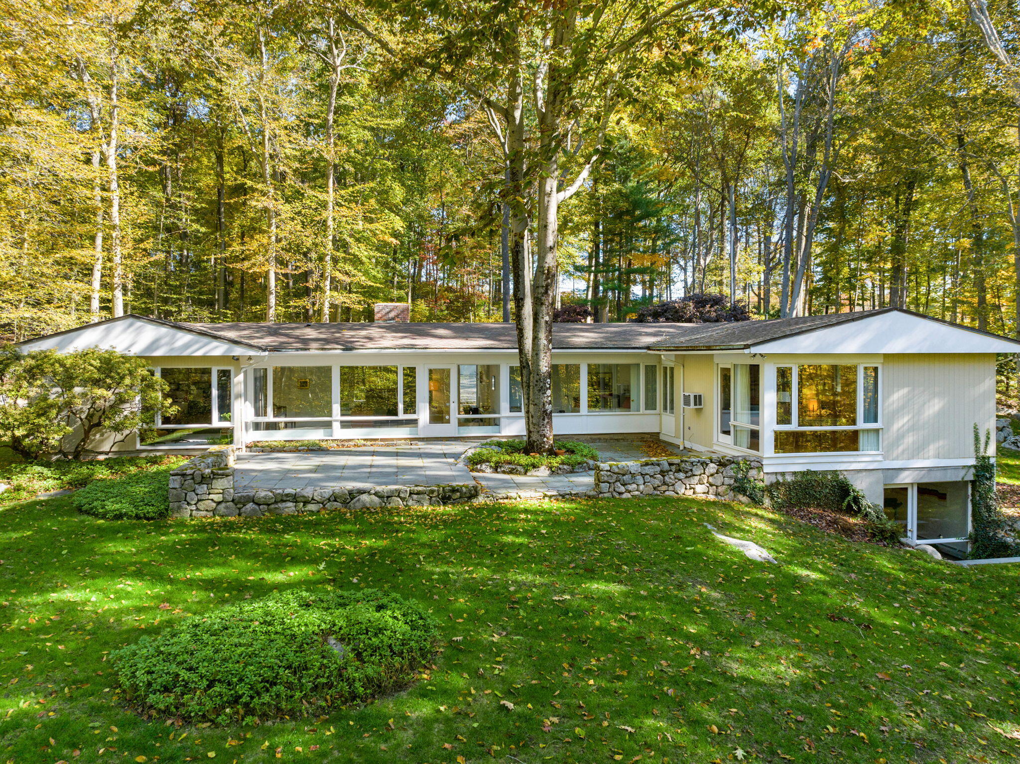 154 Indian Rock Road New Canaan, CT 06840 - Photo 3 of 33 a front view of a house with a yard table and chairs