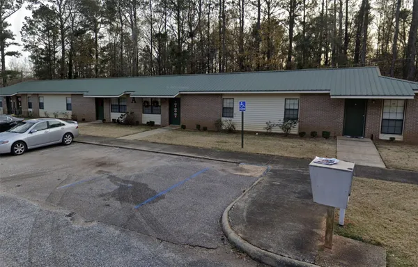 a front view of a house with yard and trees