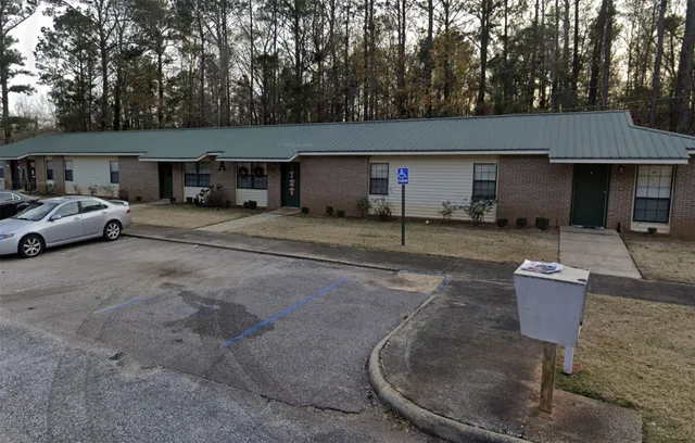 a front view of a house with yard and trees