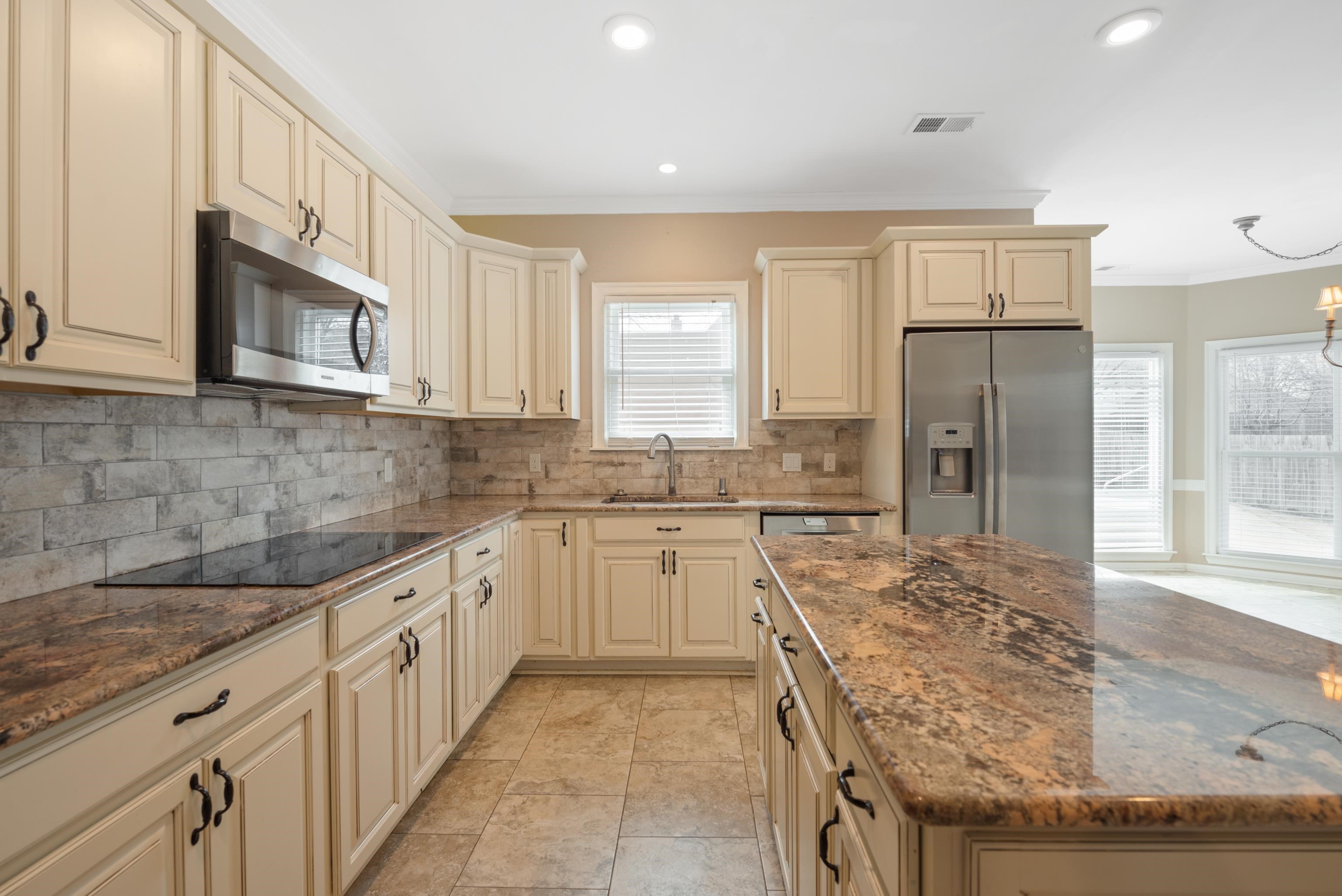 1553 John Ridge Drive Collierville, TN 38017 - Photo 11 of 40 a kitchen with stainless steel appliances granite countertop a refrigerator a sink and white cabinets
