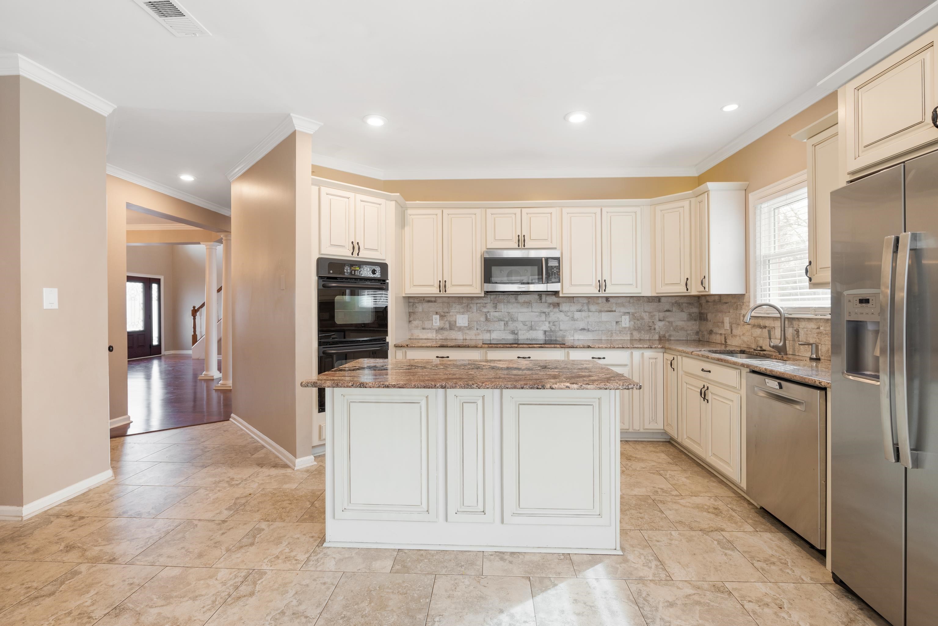 1553 John Ridge Drive Collierville, TN 38017 - Photo 13 of 40 a kitchen with kitchen island granite countertop a stove a sink and a refrigerator