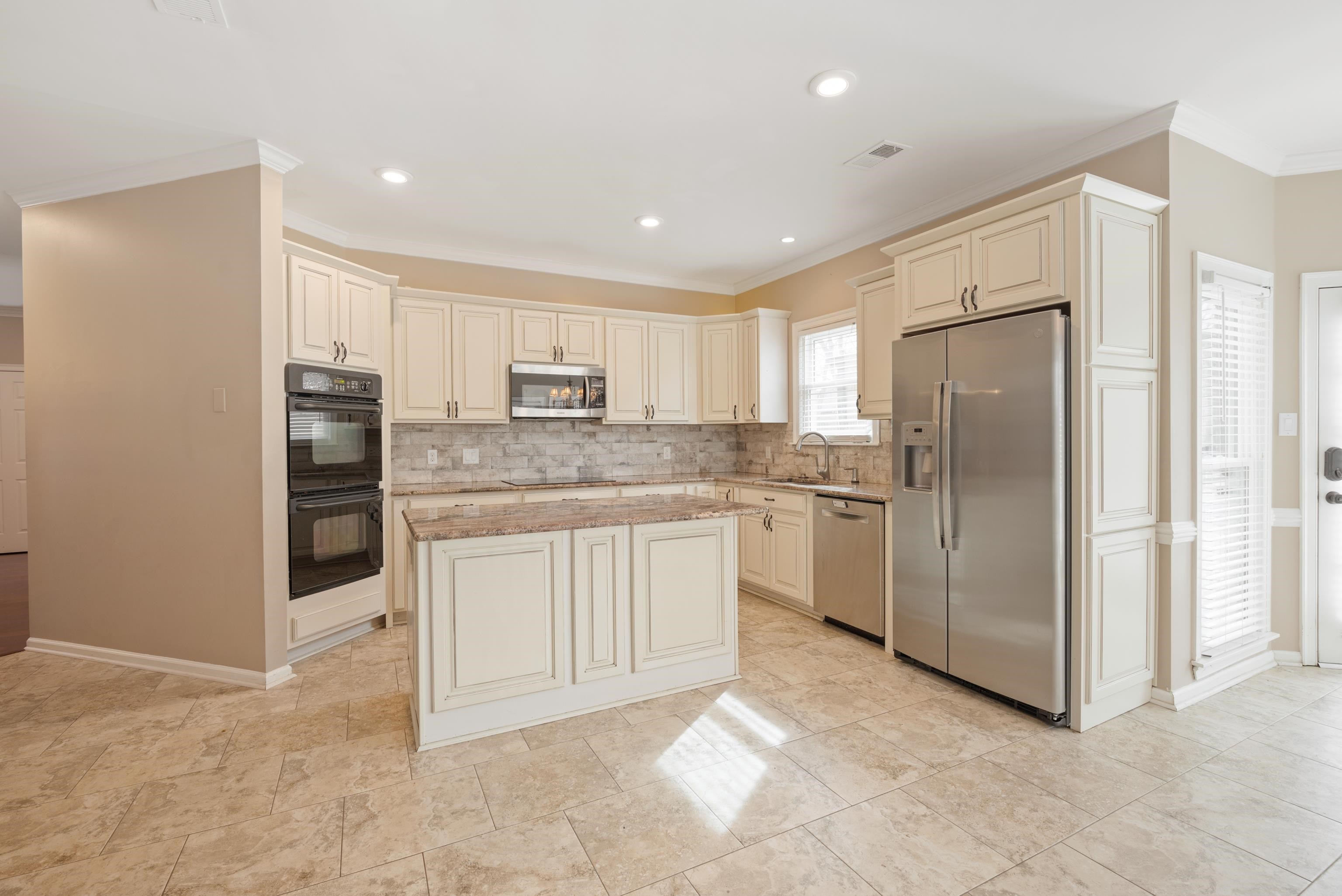 1553 John Ridge Drive Collierville, TN 38017 - Photo 15 of 40 a kitchen with stainless steel appliances granite countertop a refrigerator and a stove top oven