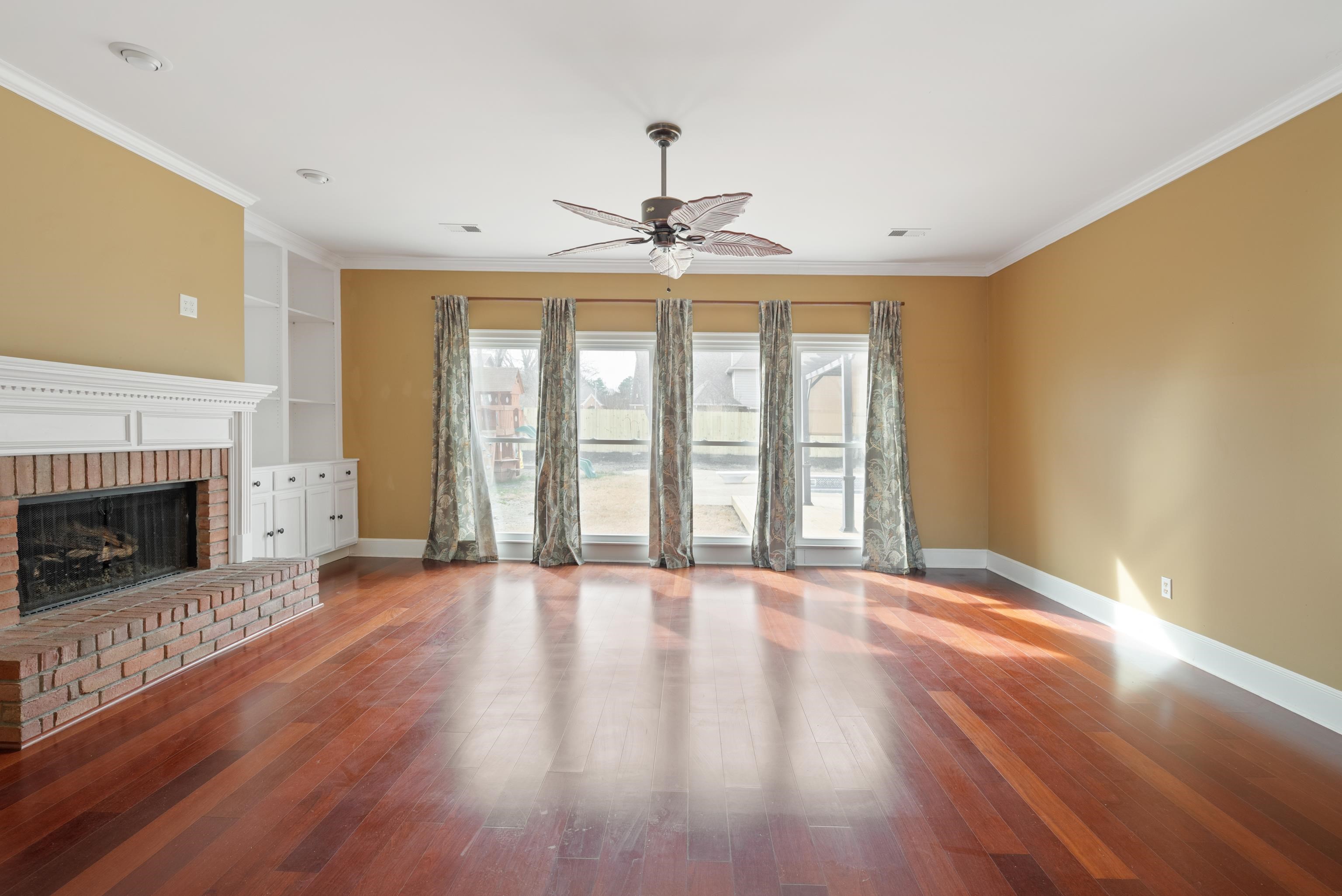 1553 John Ridge Drive Collierville, TN 38017 - Photo 20 of 40 a view of an empty room with wooden floor fireplace and a window