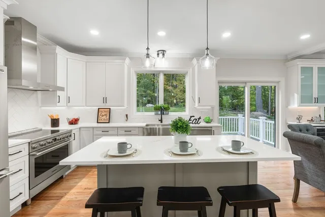 a kitchen with sink a stove and chairs