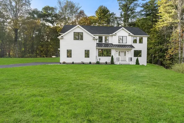 a view of a house with a big yard and large trees