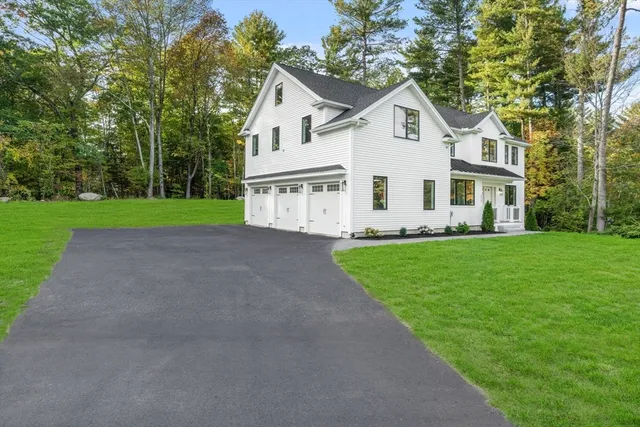 a front view of a house with a garden and trees