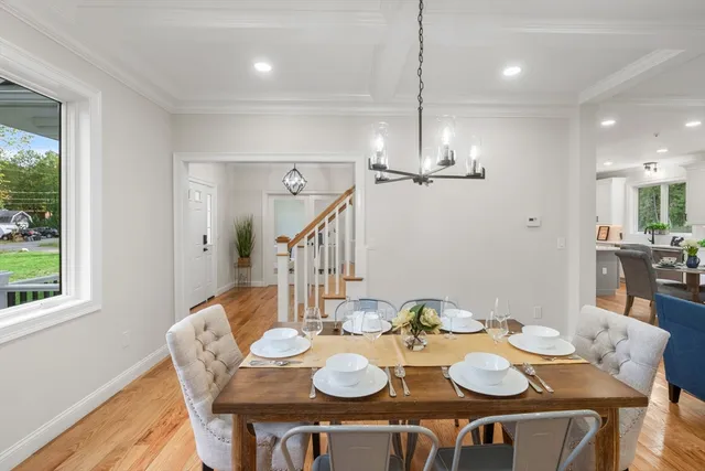 a view of a dining room with furniture a chandelier and wooden floor