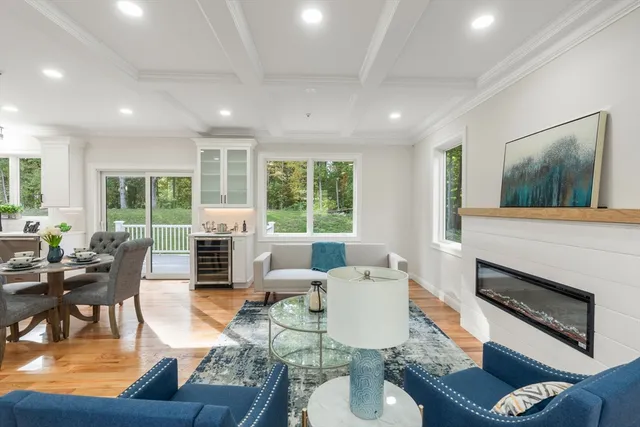 a living room with fireplace furniture and a large window