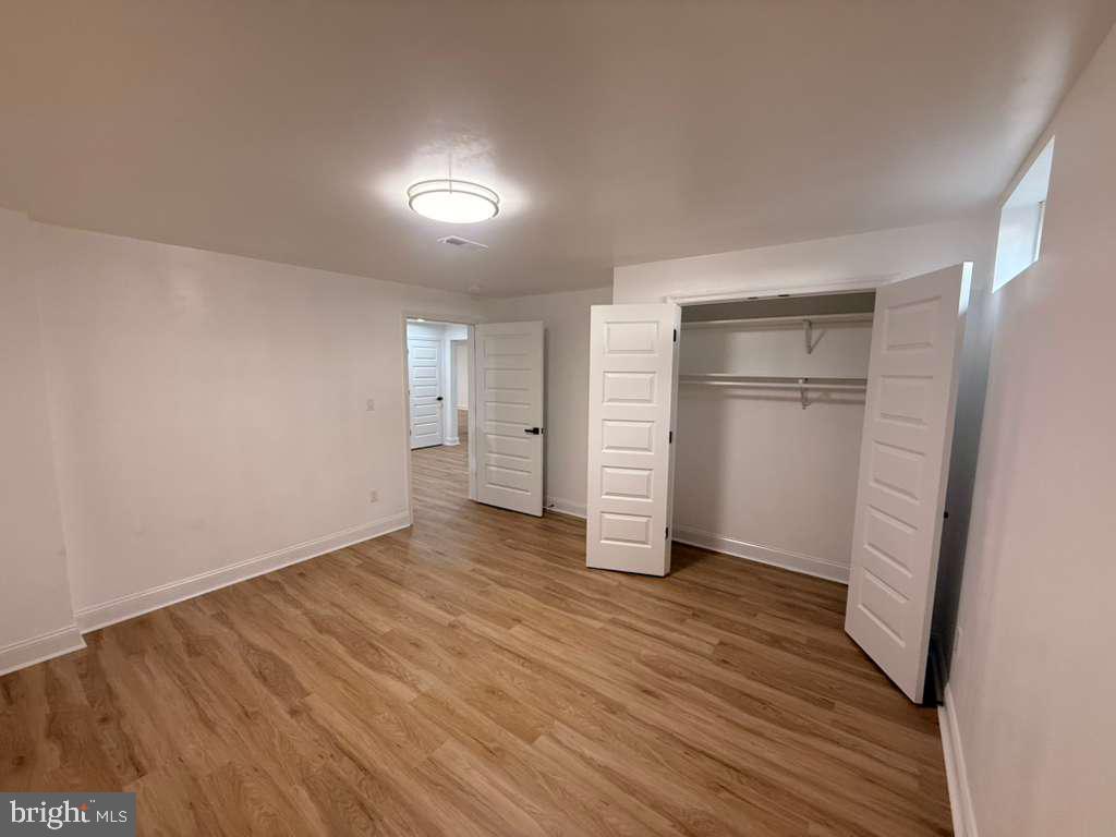 10402 Laurel Ridge Way, Unit BSMT Fredericksburg, VA 22408 - Photo 33 of 35 an empty room with wooden floor and closet