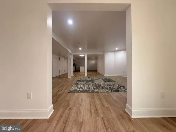 a view of a hall with wooden floor and a window