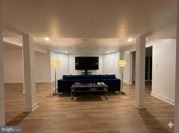 a dining hall with stainless steel appliances granite countertop a stove a sink a dining table and chairs with wooden floor