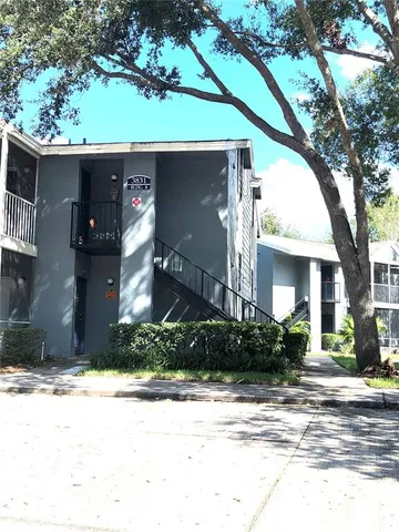 a front view of a house with a yard and potted plants