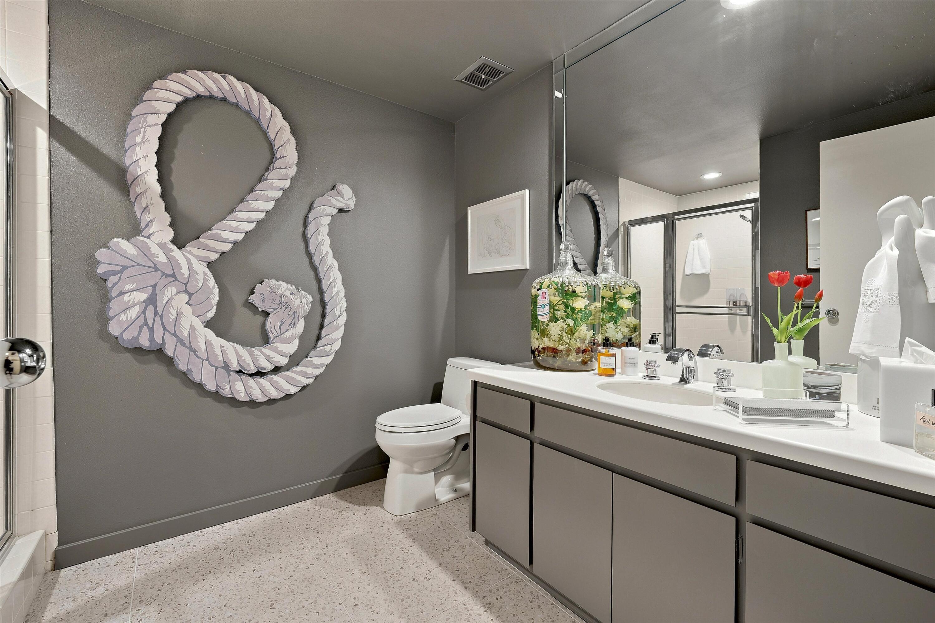 899 Island Drive, Unit 304 Rancho Mirage, CA 92270 - Photo 13 of 30 a bathroom with a toilet sink vanity and mirror