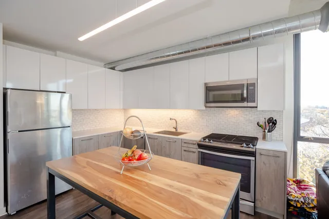 a kitchen with a appliances a refrigerator and a stove top oven