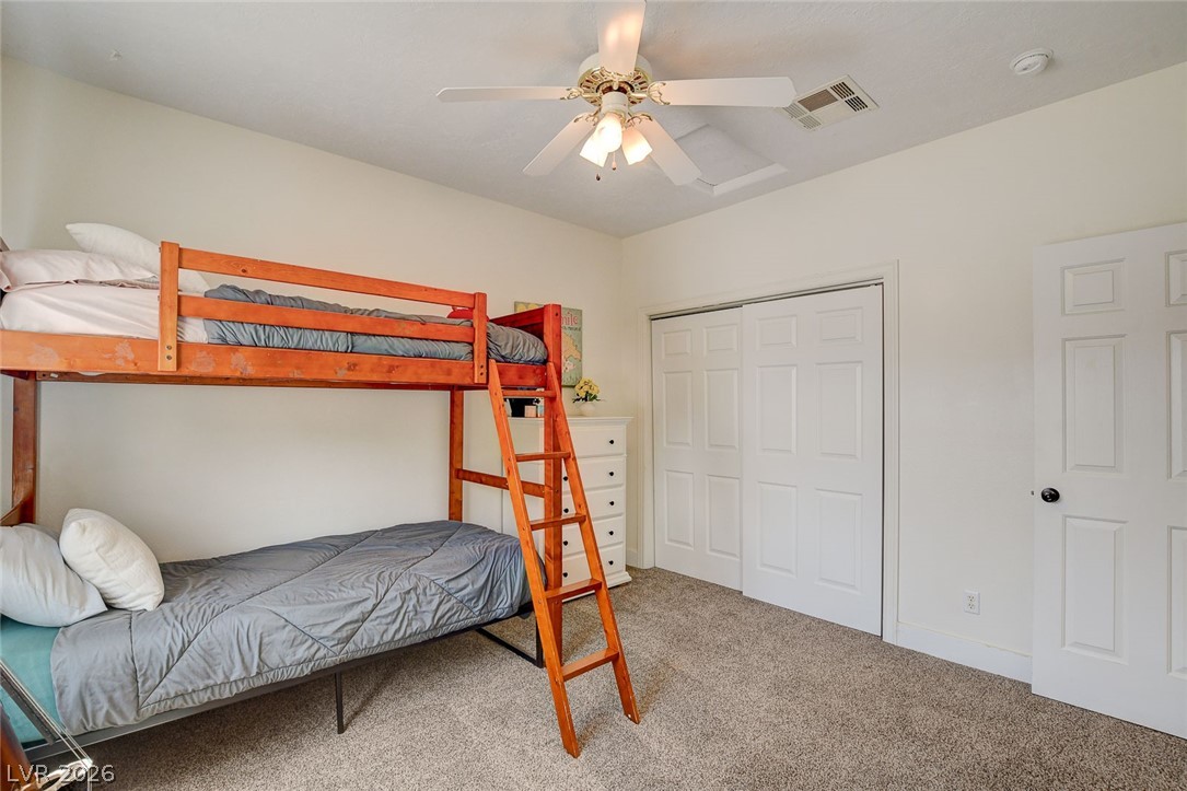 4362 Thistle Street Logandale, NV 89021 - Photo 34 of 99 A well-lit bedroom offering a versatile sleeping arrangement with carpeted floors and a ceiling fan.