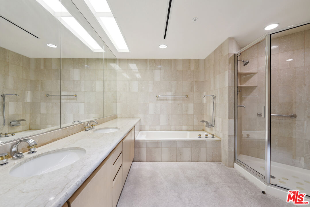 10490 Wilshire Boulevard, Unit 1402 Los Angeles, CA 90024 - Photo 14 of 67 a spacious bathroom with a tub sink shower and a mirror
