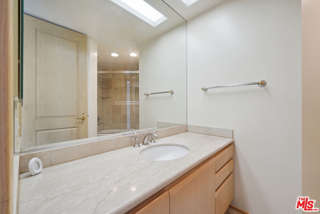 10490 Wilshire Boulevard, Unit 1402 Los Angeles, CA 90024 - Photo 20 of 67 a bathroom with a granite countertop sink and a mirror