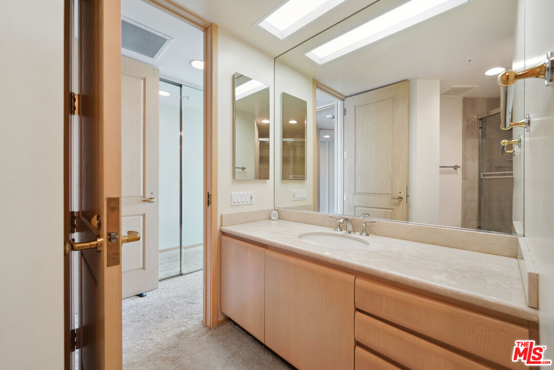 10490 Wilshire Boulevard, Unit 1402 Los Angeles, CA 90024 - Photo 22 of 67 a bathroom with a granite countertop sink mirror and double