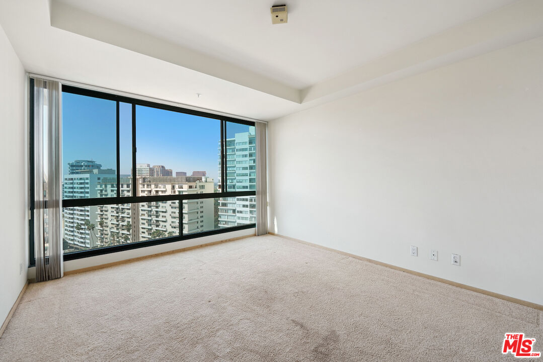 10490 Wilshire Boulevard, Unit 1402 Los Angeles, CA 90024 - Photo 24 of 67 an empty room with sliding glass door